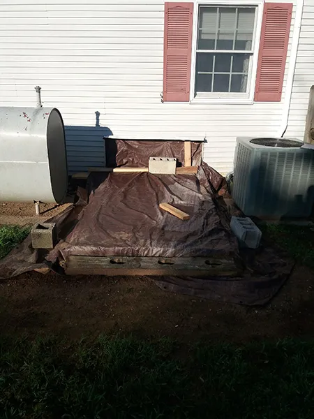 dilapidated and rotten wooden cellar door covered with a tarp